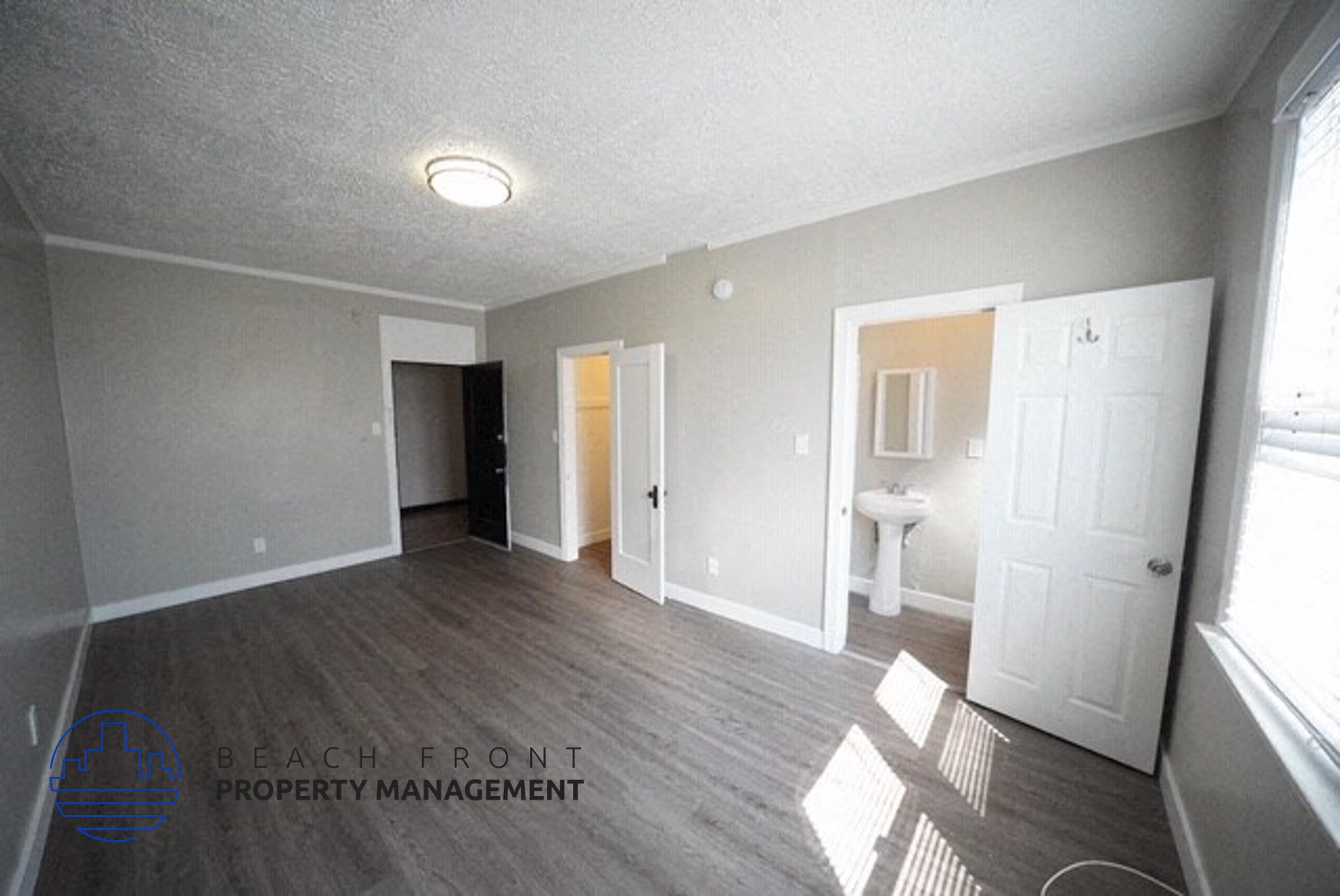 an empty living room with a bathroom and a white door
